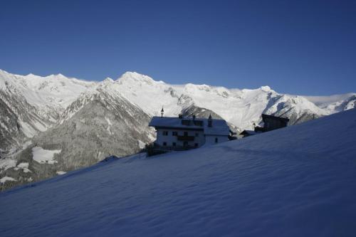 a building on top of a snow covered mountain at Schauinstal Appartement 2 in Lutago
