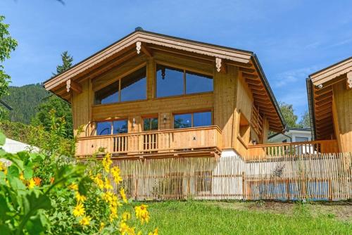 a large wooden house with a large deck at Gams Lodge 2 in Weng