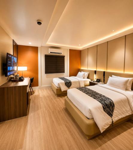 a hotel room with two beds and a flat screen tv at Madigun Hotel and Events in San Francisco