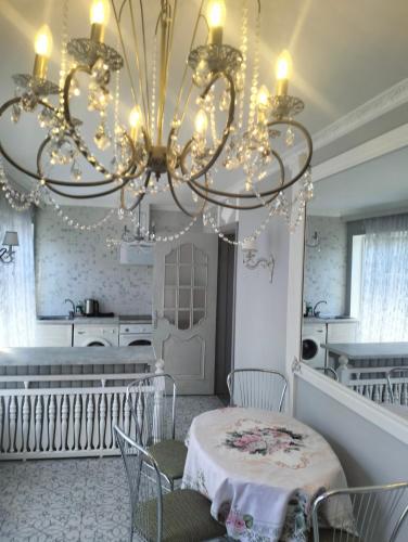 a dining room with a chandelier and a table at Apartment Sonata in Jūrmala