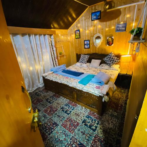 a bedroom with a bed with blue pillows at Blackpearl in Srinagar