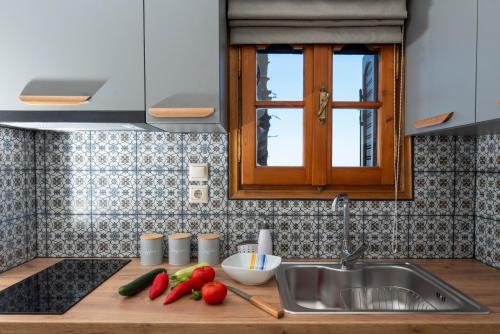 a kitchen with a sink and some vegetables on a counter at Adilon in Tsagarada