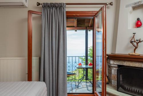 a bedroom with a fireplace and a view of the ocean at Adilon in Tsagarada