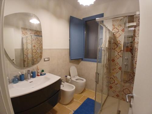 a bathroom with a sink and a toilet and a mirror at Casale Mute Terre in Tuglie