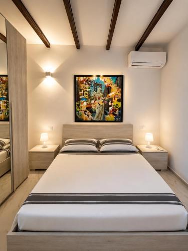 a bedroom with a large white bed with two lamps at Domus Tarquinia in Tarquinia