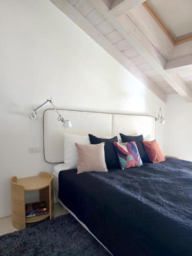 a bedroom with a black bed with pillows at IseoLakeRental - Collina Divina in Solto Collina