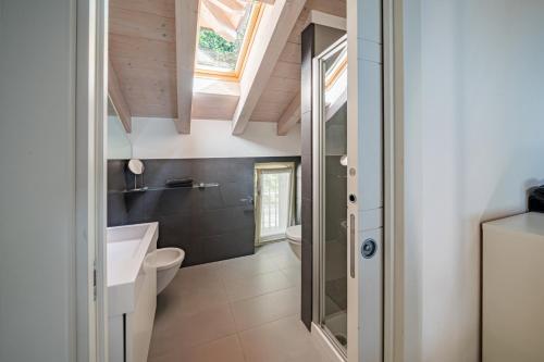 a bathroom with a white toilet and a sink at IseoLakeRental - Collina Divina in Solto Collina