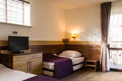 a hotel room with two beds and a flat screen tv at Willa Focus in Mielno