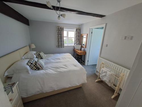 a bedroom with a white bed and a desk at The Old Stone Barn in Warrington