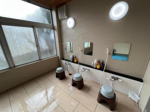 a bathroom with two urinals and two toilets at Asama Onsen FAN! MATSUMOTO in Matsumoto