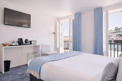 a hotel room with a bed and a large window at Miragaia - Riverside Suites - Adults Only in Porto