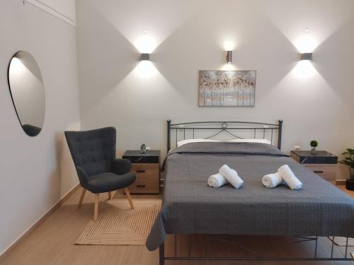a bedroom with a bed with two pillows and a chair at Orange Grove in Plomari
