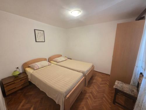 a bedroom with two beds and a clock on the wall at Apartment Boris in Labin