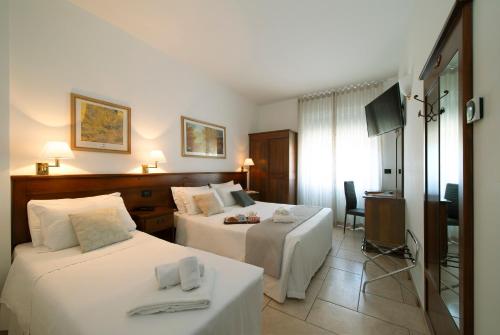 a hotel room with two beds and a television at Hotel Nuovo Metrò in Milan
