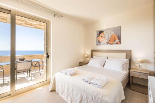 a bedroom with a bed and a view of the ocean at Villa Thea in Triopetra