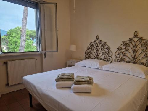 a bedroom with a large white bed with towels on it at Casa del Sole in Versilia in Cinquale