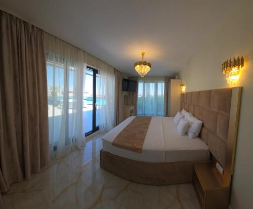 a bedroom with a large bed and a large window at Penthouse Rico in Eforie Nord