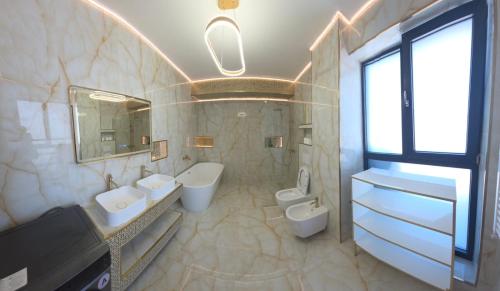 a bathroom with two sinks and two toilets at Penthouse Rico in Eforie Nord