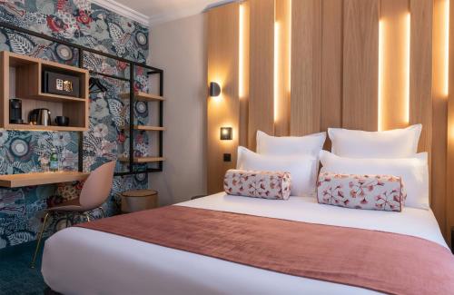 ein Schlafzimmer mit einem großen weißen Bett und zwei Kissen in der Unterkunft Leonardo Boutique Hotel Paris Opera in Paris