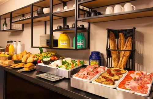 ein Buffet mit verschiedenen Speisen an einer Theke in der Unterkunft Leonardo Boutique Hotel Paris Opera in Paris