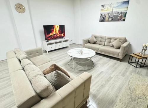 a living room with a couch and a tv at Stylish & Relaxing Modernes Apartment mit Privatparkplatz in Gelsenkirchen