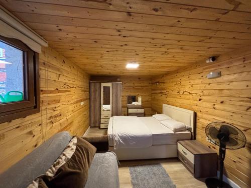 a bedroom with a bed in a wooden room at Desera Pansiyon in Uzungöl