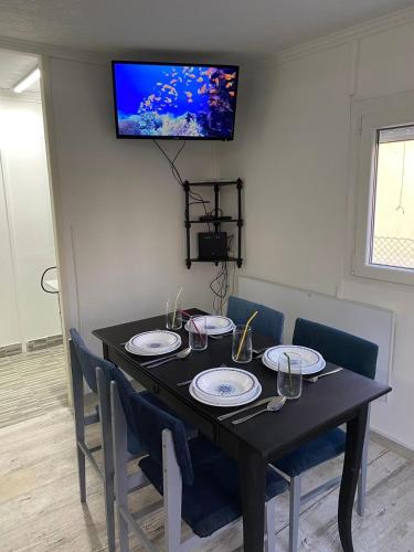 a black table with chairs and a television on a wall at KissKovács Lak in Cserkeszőlő
