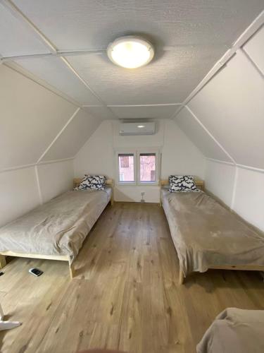 a room with two beds in it with a ceiling at KissKovács Lak in Cserkeszőlő