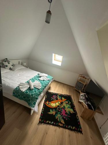a bedroom with a bed and a rug on the floor at Casa cu Poveste in Dorna Arini