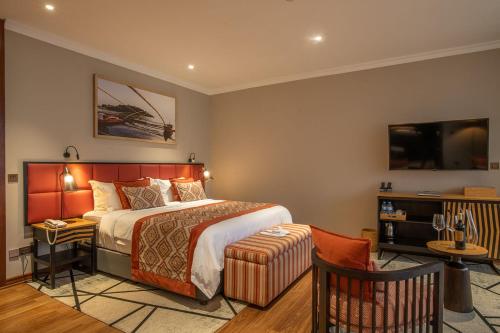 a hotel room with a bed and a tv at LUX* Lake Kivu 