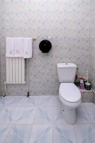 a bathroom with a toilet and a radiator and towels at VILLA Lafayette in Tunis