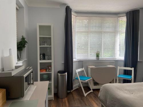 a bedroom with a bed and a tv and a window at Spacious Double Studio-style room in Orpington
