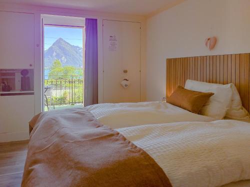 a bedroom with a bed with a view of a mountain at Hotel Du Lac in Därligen
