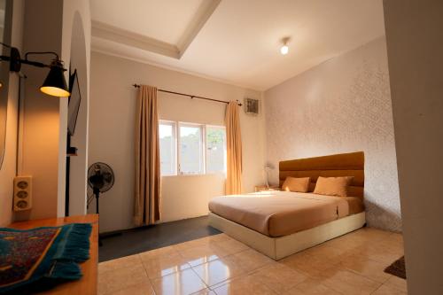 a bedroom with a bed and a window at Al Barra Syariah Hotel in Bukittinggi