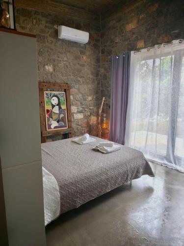 a bedroom with a bed and a stone wall at Casa del Quadro in Chios