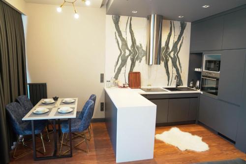 a kitchen with a white counter and a table and chairs at Benesta Residence by NewInn in Istanbul