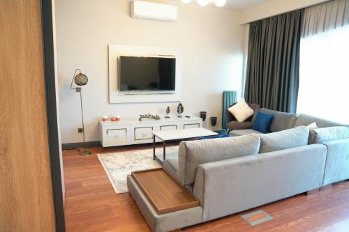 a living room with a couch and a tv at Benesta Residence by NewInn in Istanbul