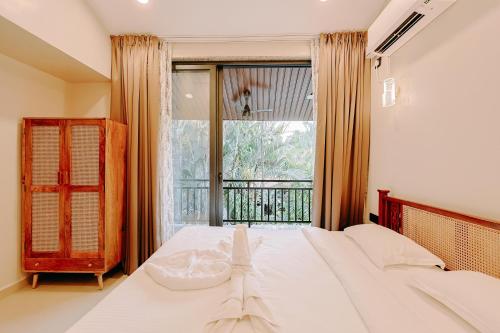 a bedroom with a bed and a large window at Tiadoro Villa in Calangute