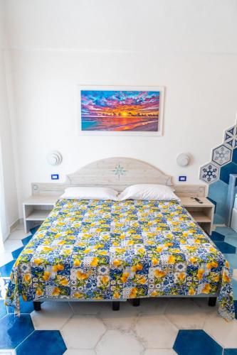 a bedroom with a bed with a colorful quilt at Agriresort La Dragonara in Bacoli