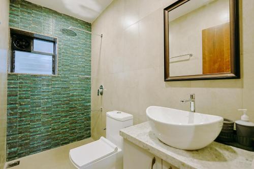 a bathroom with a sink and a toilet and a mirror at Tiadoro Villa in Calangute