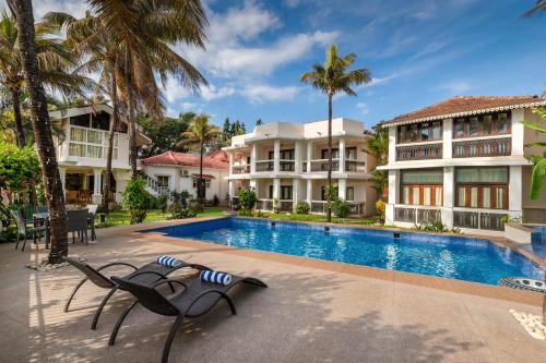 an image of a resort with a swimming pool and palm trees at Resort Coqueiral - A Portuguese Heritage Stay by the Sea in Candolim