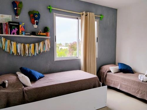 a bedroom with two beds and a window at YellowStone in Balneario Buenos Aires