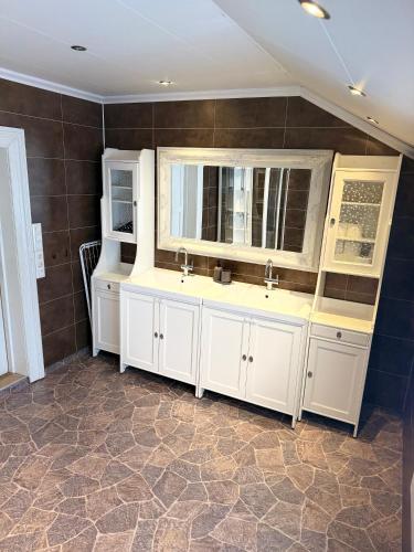 a bathroom with two sinks and two mirrors at Finnegården Røros in Røros
