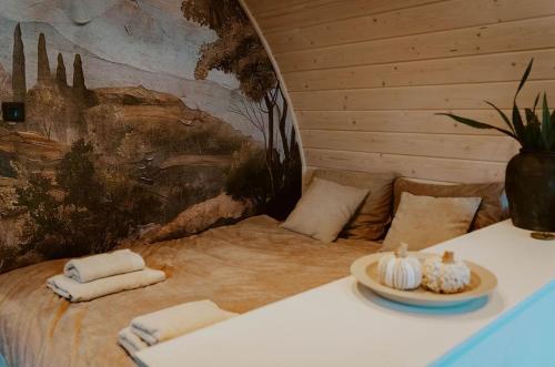 a room with a bed with towels and a painting at luxury cottage with sauna in Milsbeek