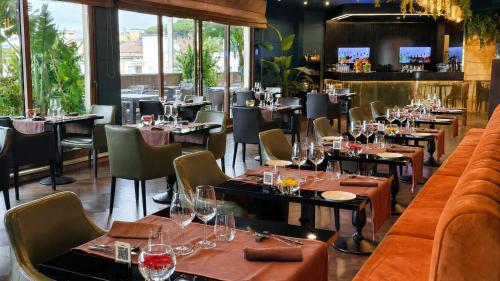 a restaurant with tables and chairs with wine glasses at Radisson Blu GHR Rome in Rome