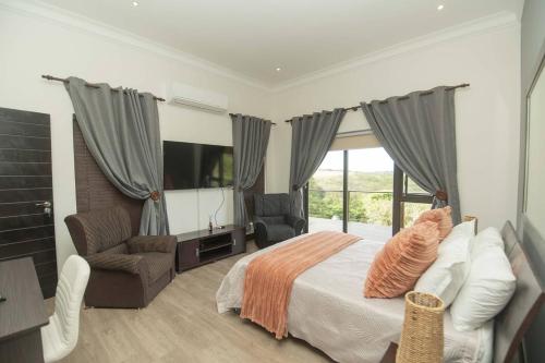 a bedroom with a bed and a chair and a television at Bevuline in Gqeberha