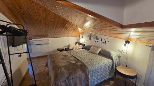 a bedroom with a bed with a wooden ceiling at La Ribera in Arroyo Frio