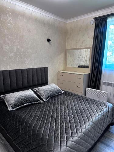 a bedroom with a bed and a dresser and a mirror at Jermuk Cozy Apartment in Jermuk