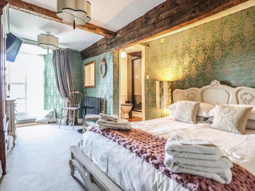 a bedroom with a large bed with towels on it at Plas Dolguog in Machynlleth