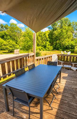 a blue picnic table on a deck with two chairs at La Maison des Délices in Dosches